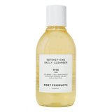 Detoxifying Daily Cleanser  bottle with gold color liquid on white background