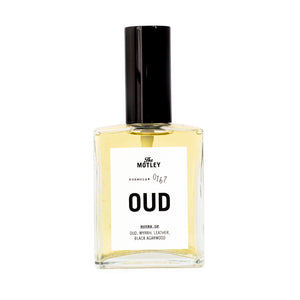 The Motley Oud Fragrance in a glass bottle with gold liquid and a black pump cap against a white background