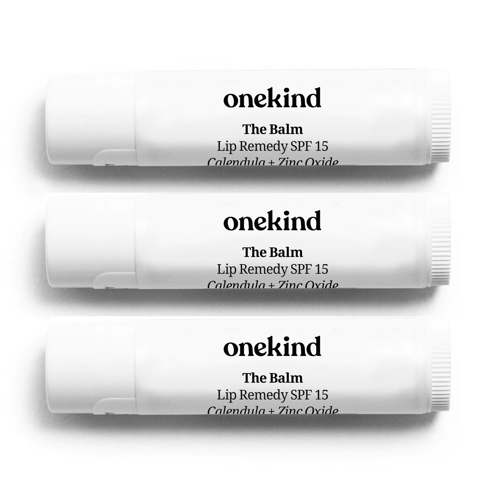 3 sticks of The Balm Lip Remedy SPF 15 lined up against a white background.