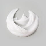 The white, velvety cream of the Buckler's Daily Face Repair on a light gray background.