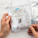 Hands hold a Port Products Intense Recovery Treatment Mask in a silver pouch.
